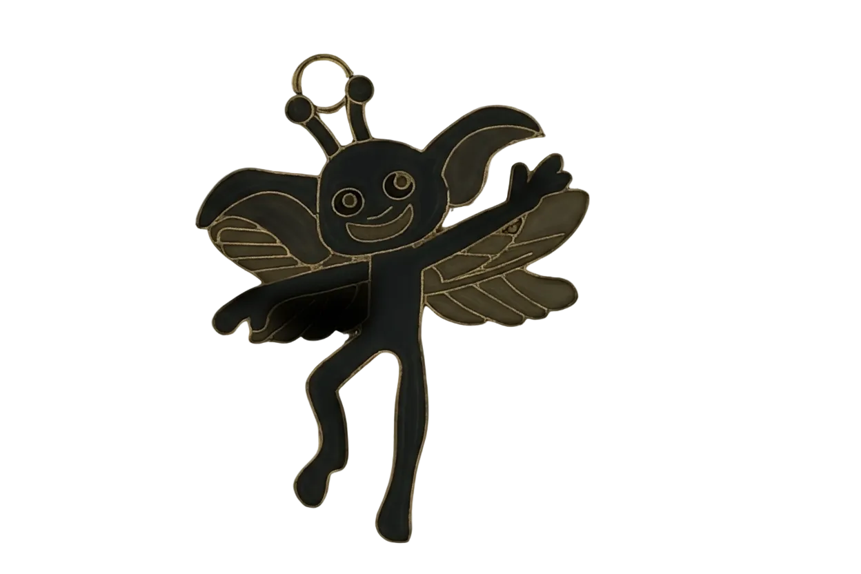 Close-up of a black and gold winged fairy charm with a smiling face.