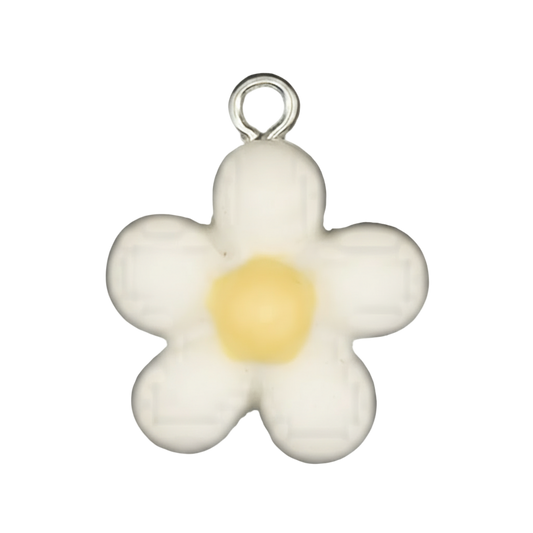 close-up of a small white daisy charm with a yellow center on a black background