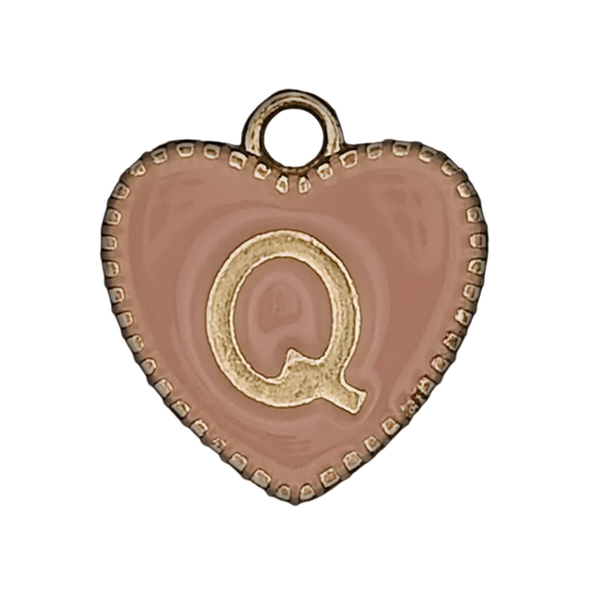 close-up of pink heart-shaped charm with gold letter Q