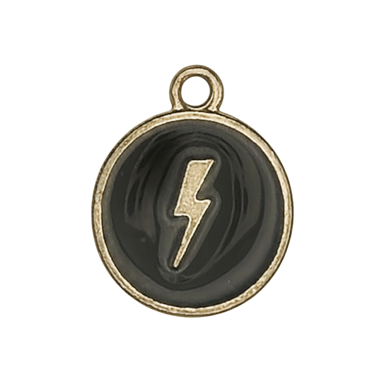 Close-up of a small round black-and-gold lightning bolt charm.