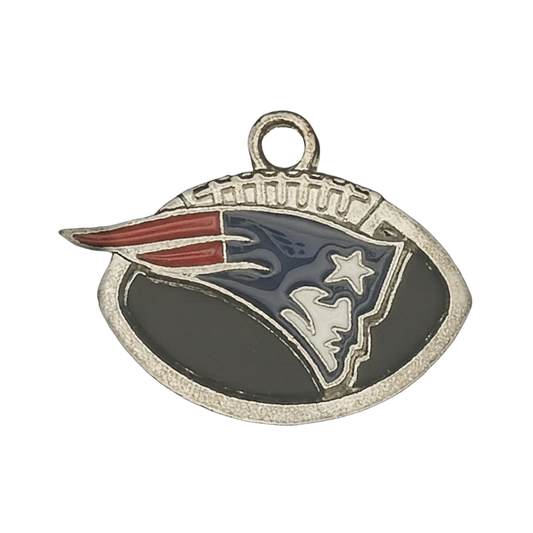 Close-up of football-shaped enamel charm with stylized profile and star in red, white, and blue on a black background.