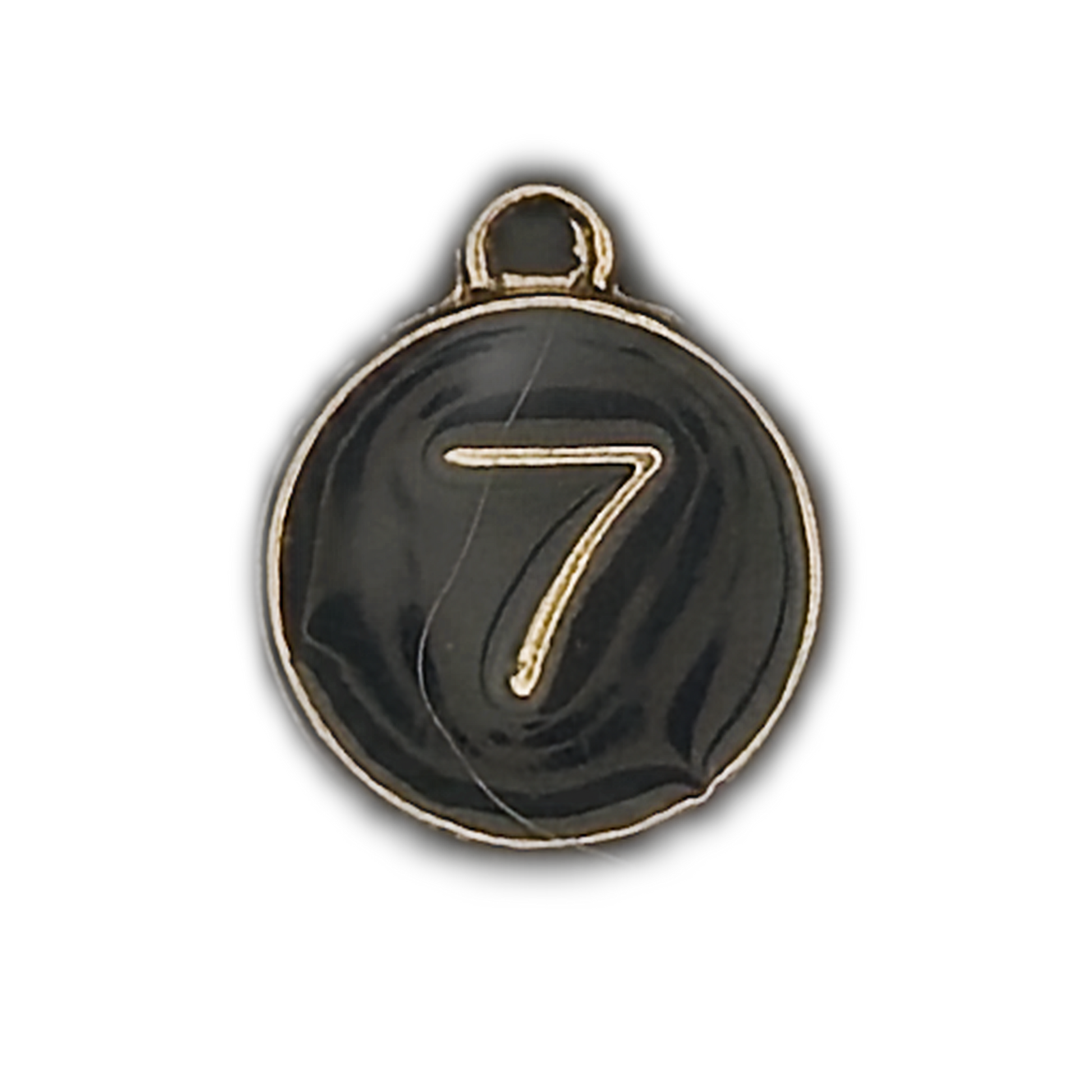 close-up of round black charm with gold number 7 and border on black background