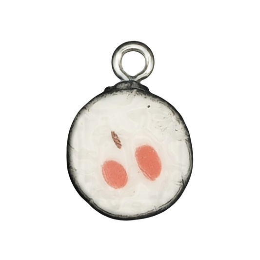 close-up round sushi roll charm with white rice center, two orange ovals, and black rim on black background