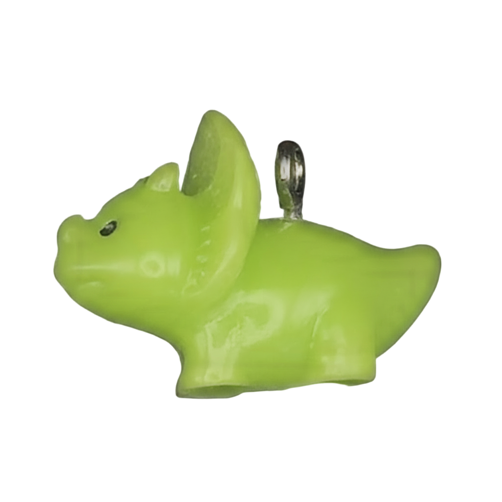 close-up of a small green dinosaur charm on a black background