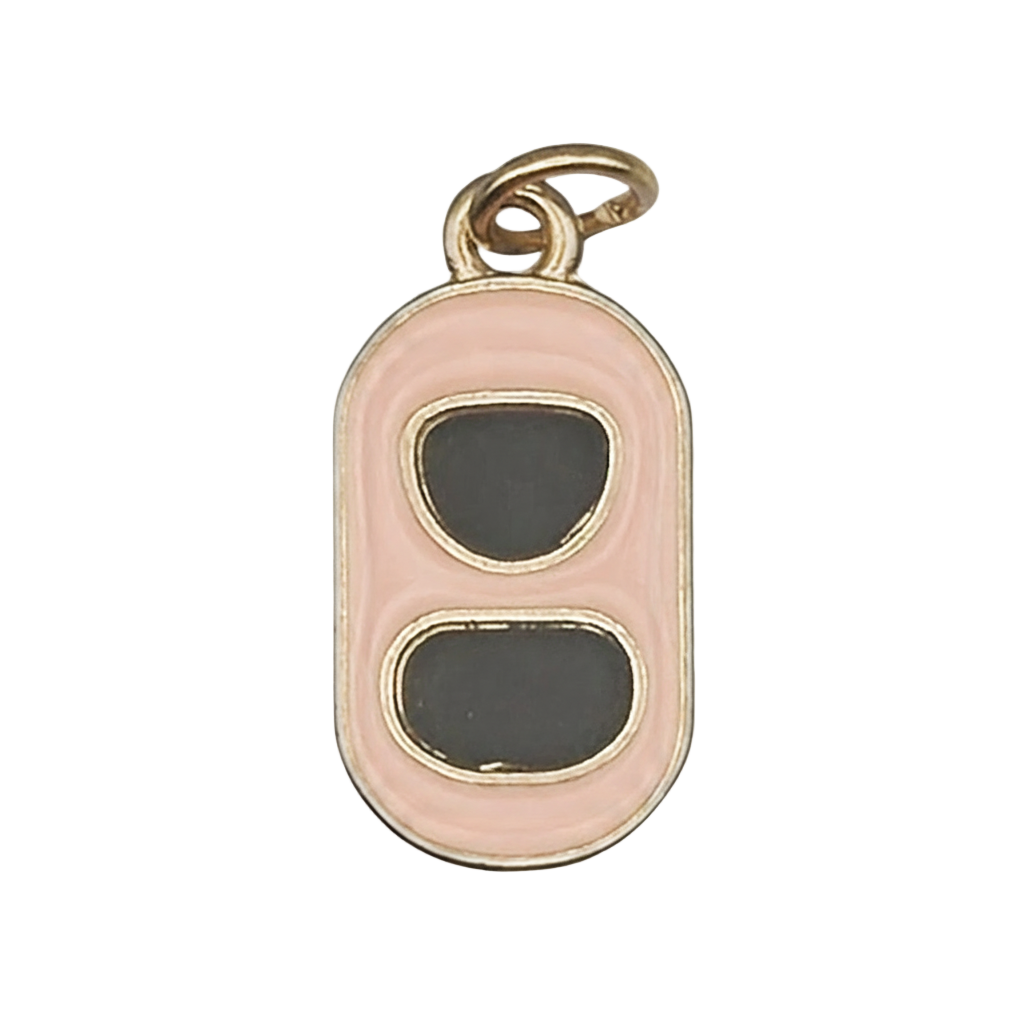 Close-up of a gold-tone soda can tab charm with pink border and black enamel ovals.