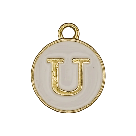 Close-up of a round white enamel charm with a gold letter U.