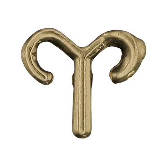 close-up of a small gold Aries zodiac glyph charm on a black background