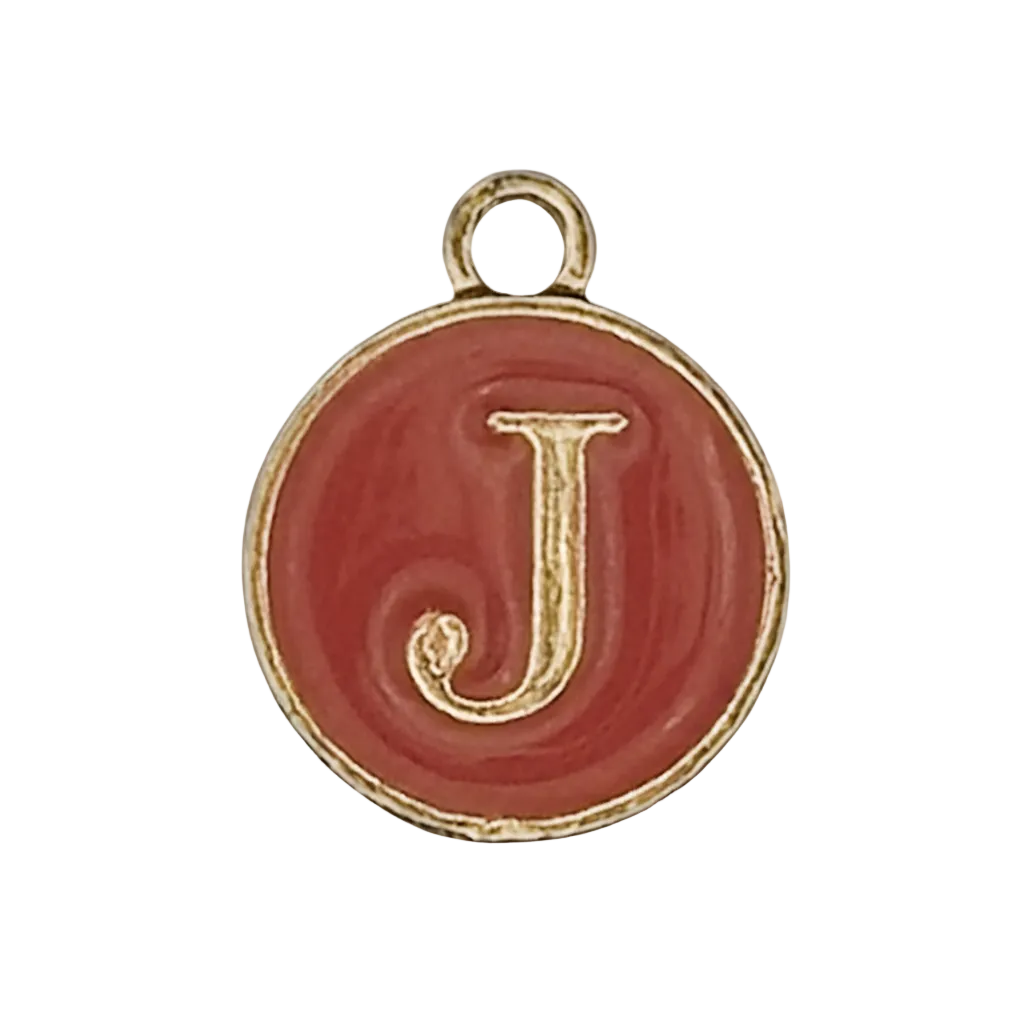 close-up of a round red enamel charm with a gold letter J and gold-tone rim on a black background