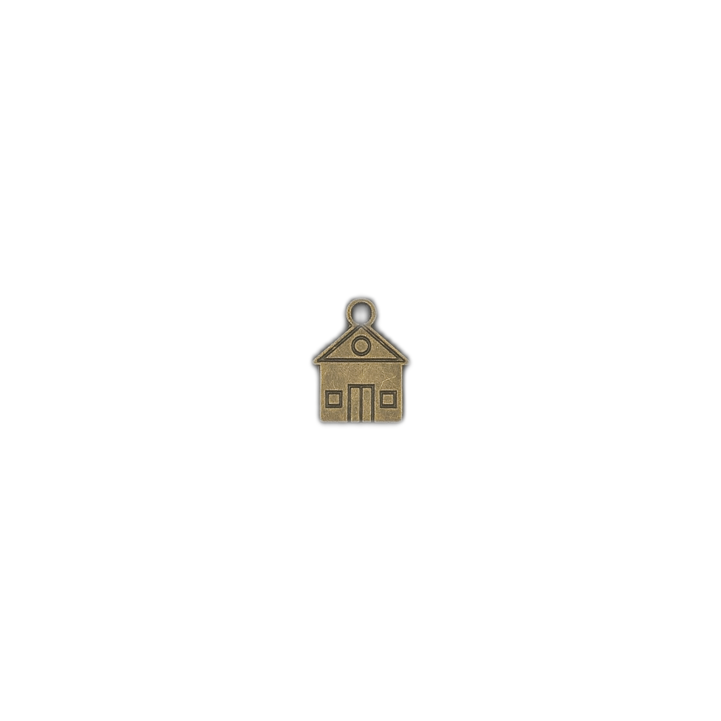 small antique brass house charm on a black background