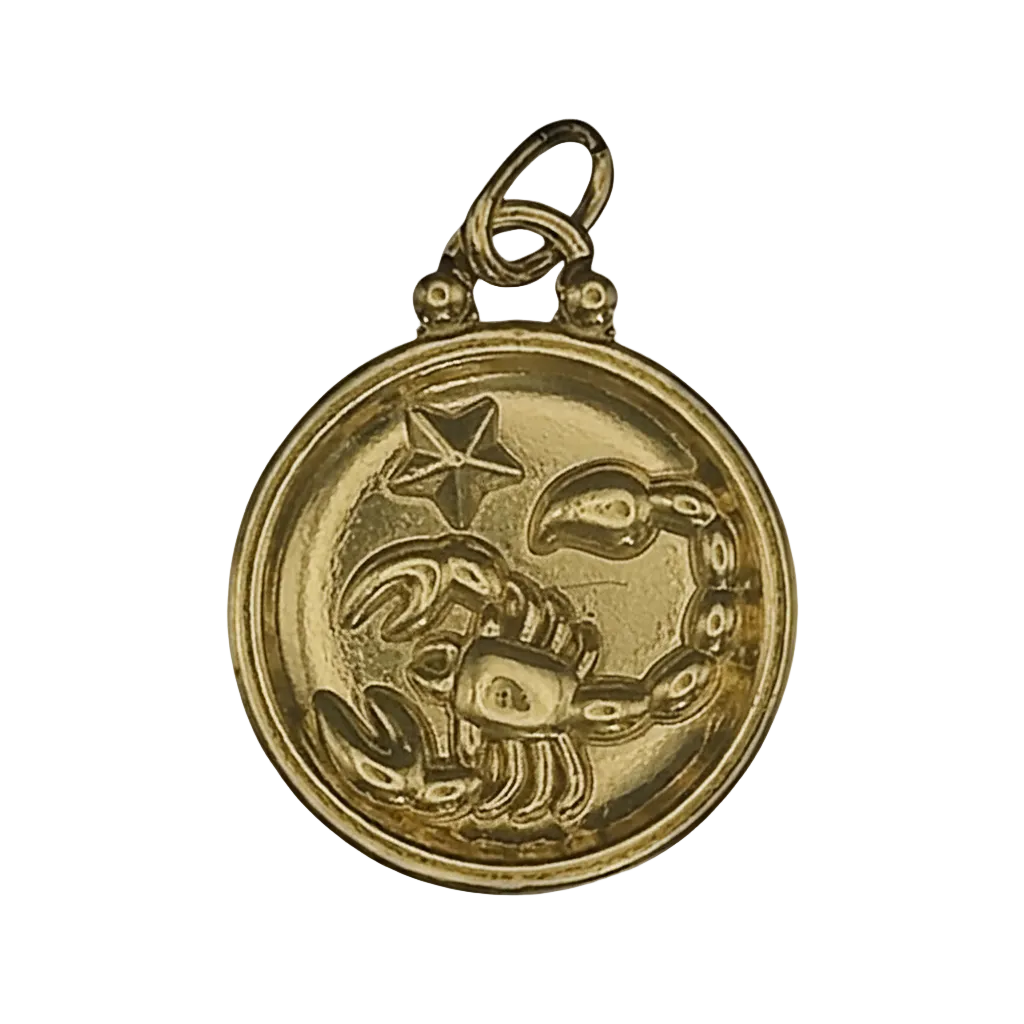 close-up of gold round scorpio zodiac charm with star on black background