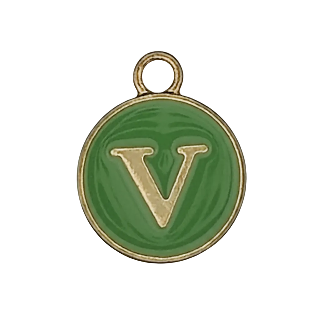 close-up of round green enamel charm with gold letter V and gold edge on black background