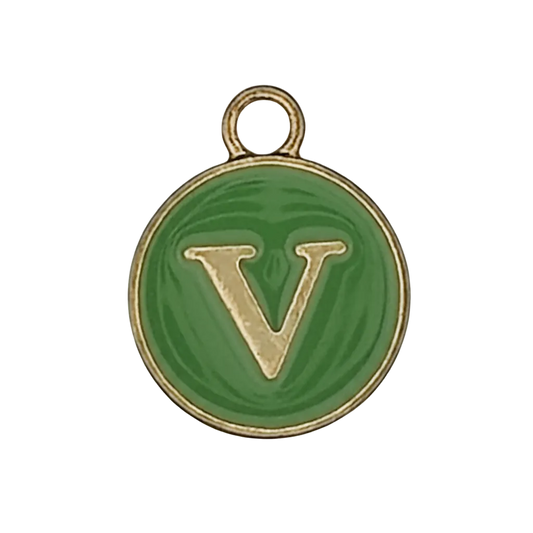 close-up of round green enamel charm with gold letter V and gold edge on black background