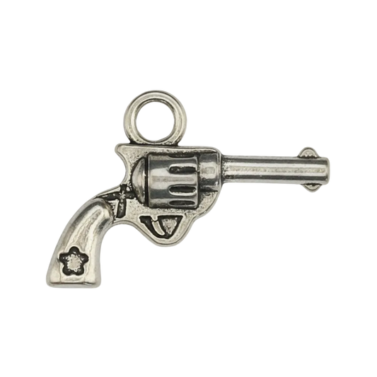 close-up of a small silver revolver-shaped charm on a black background