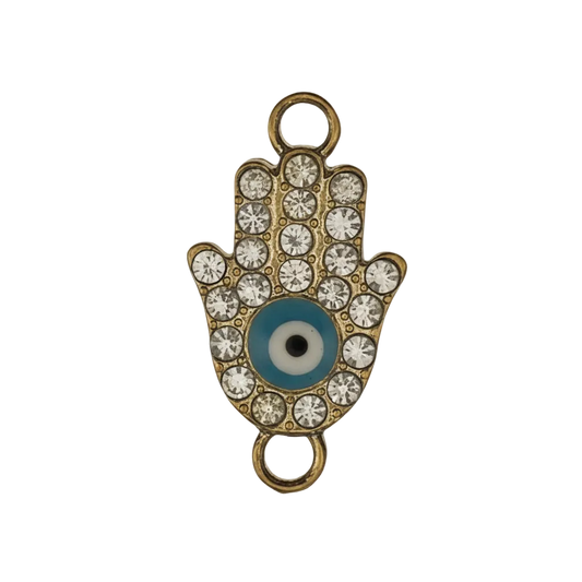 close-up of a gold-tone hamsa hand charm with clear rhinestones and a blue evil eye on a black background