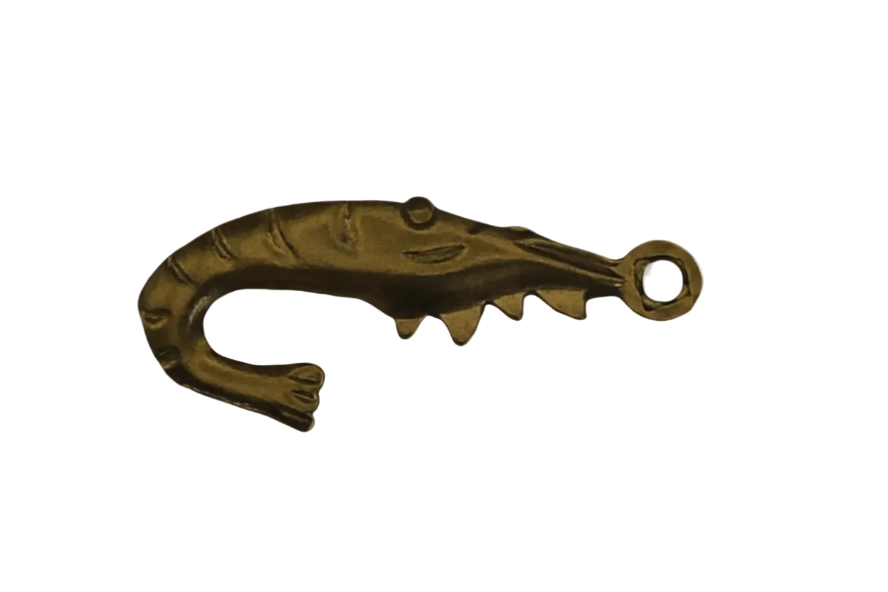 Close-up of a gold-tone shrimp-shaped charm on a black background.