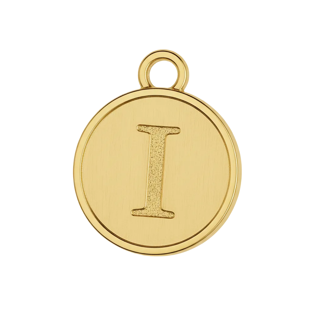 Close-up of round gold-tone charm with cream center and raised letter I.