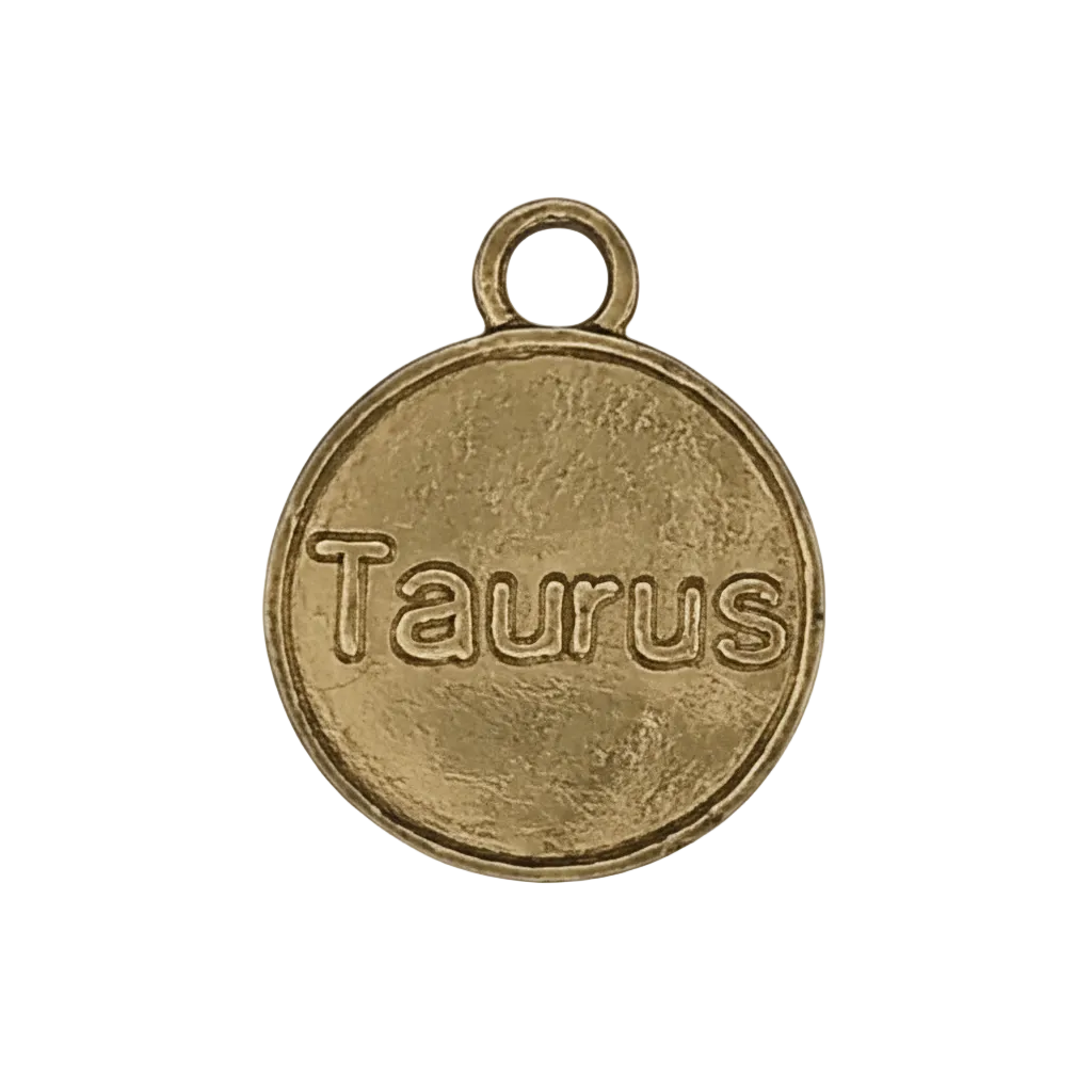 close-up of a round gold-tone charm engraved 'Taurus' with a small top ring on a black background