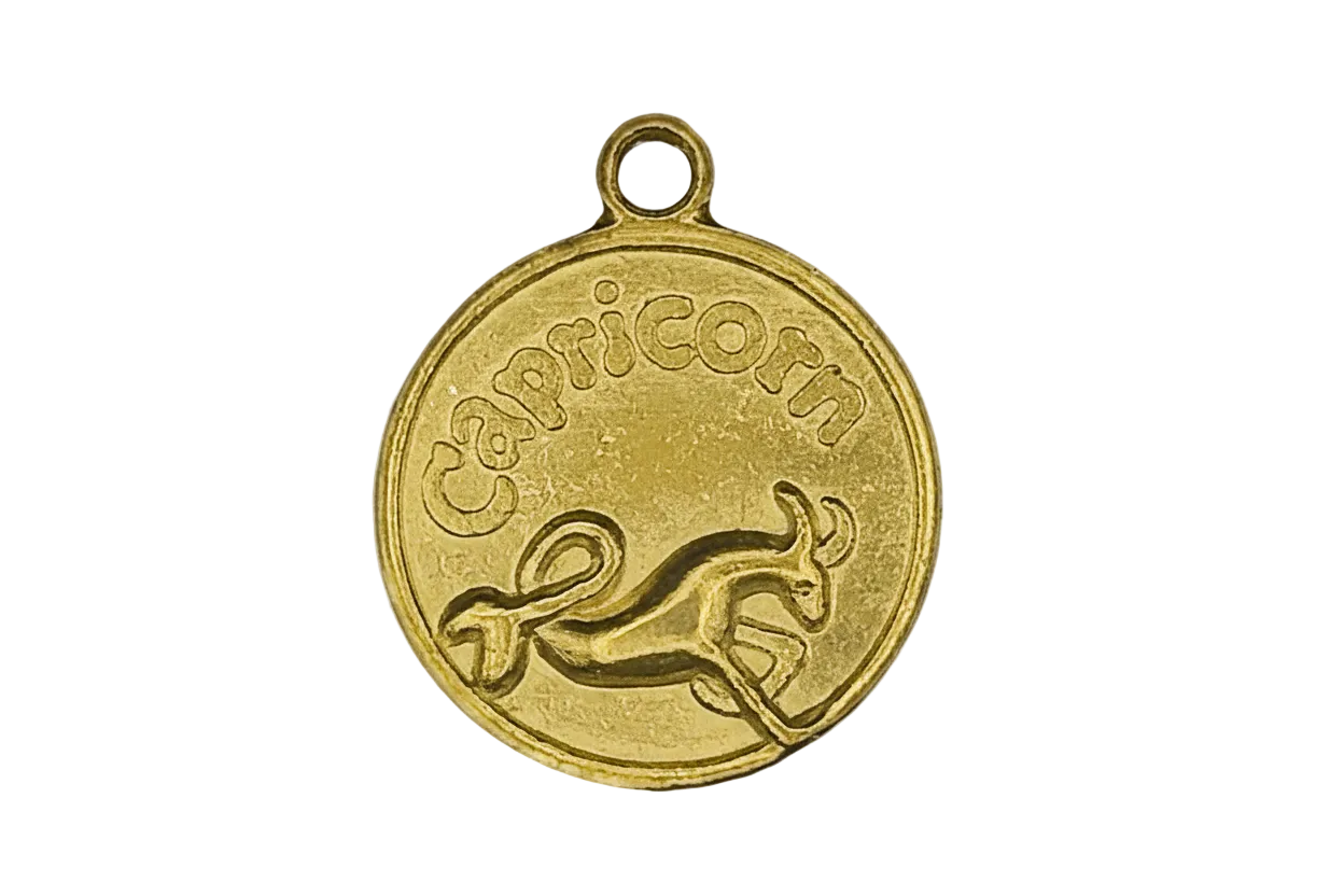 Gold round 'Capricorn' zodiac coin charm with sea-goat design, close-up