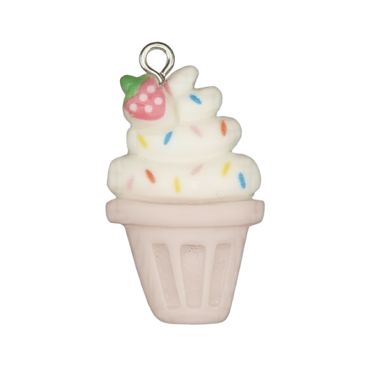 Close-up of a soft-serve ice cream cup charm with rainbow sprinkles and a small strawberry in a pink cup on a black background.