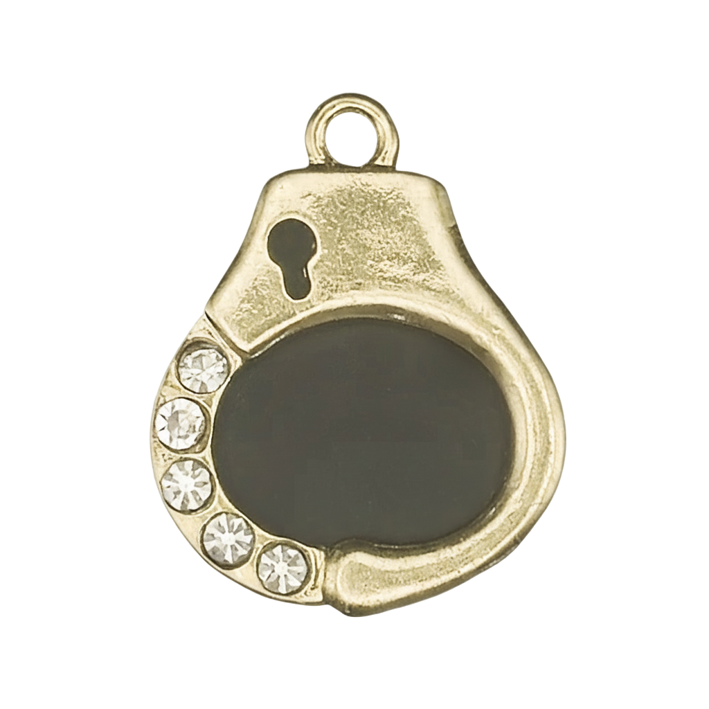 gold-tone handcuff charm with black enamel center and five clear rhinestones on a black background, close-up