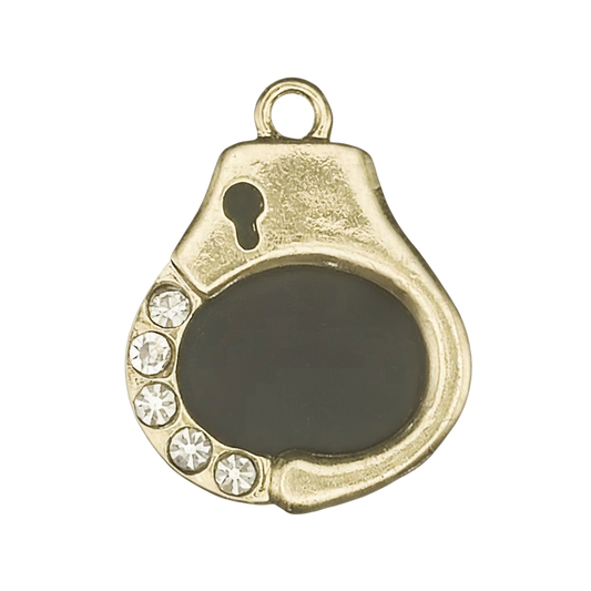 gold-tone handcuff charm with black enamel center and five clear rhinestones on a black background, close-up