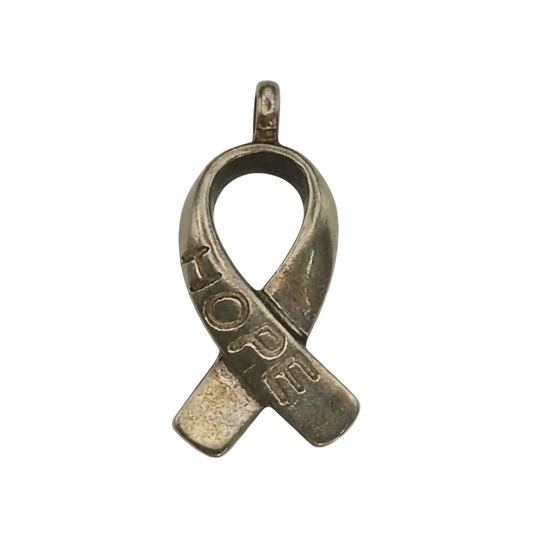 close-up of gold-tone awareness ribbon charm with 'HOPE' engraving on a black background