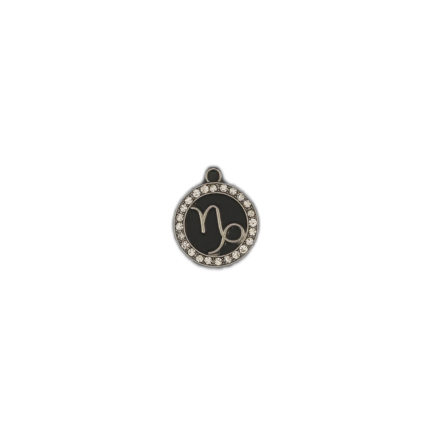 Small round black Capricorn zodiac charm with rhinestone border centered on black background.