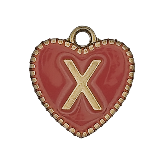 Close-up of a red heart charm with a gold letter X.