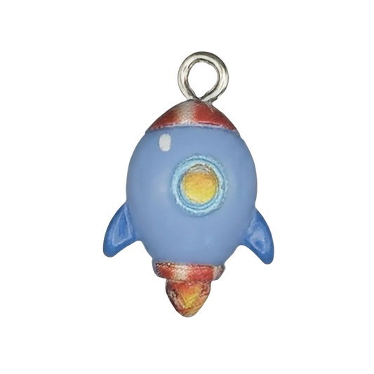 close-up of blue rocket ship charm with red and yellow details on a black background