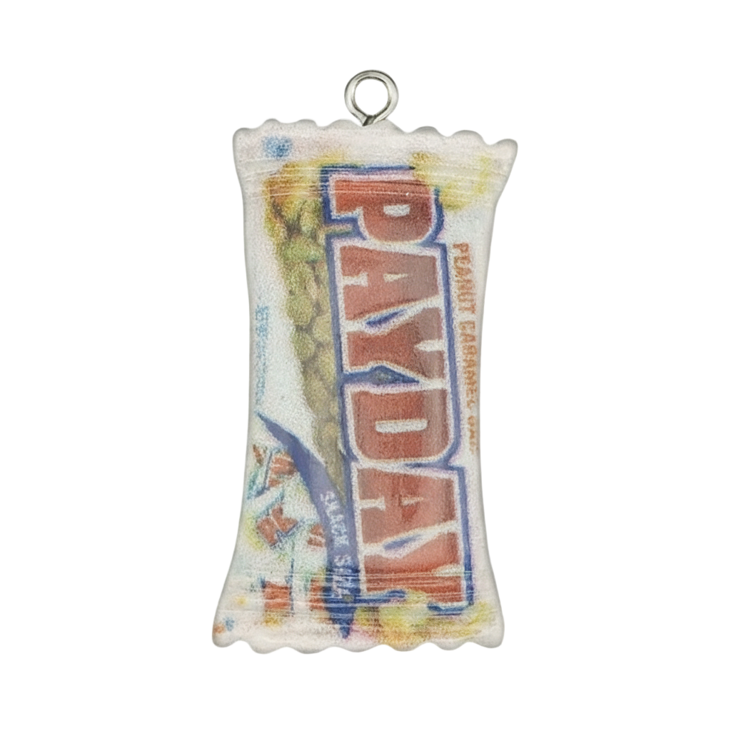 close-up of a miniature candy bar wrapper charm with 'PAYDAY' text, on a black background
