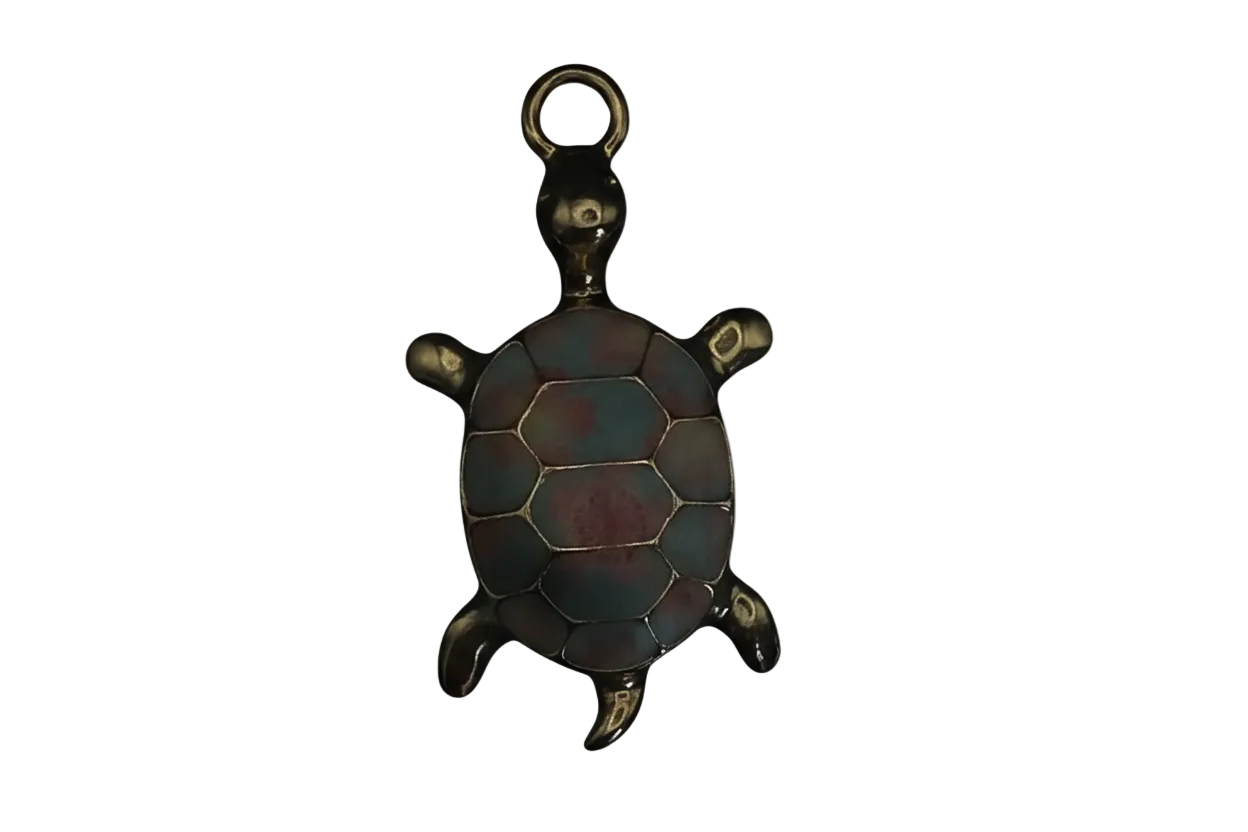 Close-up of a gold-tone turtle charm with a blue and red enamel shell on a black background.