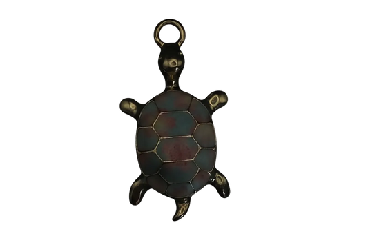 Close-up of a gold-tone turtle charm with a blue and red enamel shell on a black background.