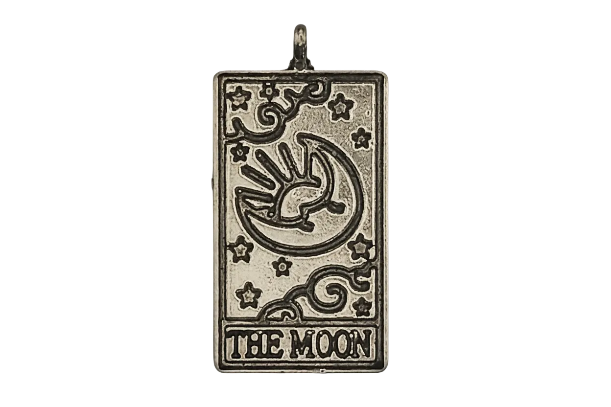 Rectangular silver-tone charm with engraved crescent moon, stars, and text THE MOON on a black background.
