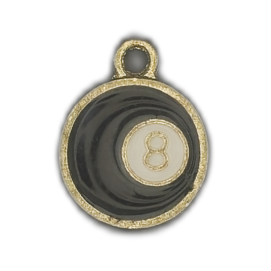 close-up of black enamel 8-ball charm with gold trim on black background