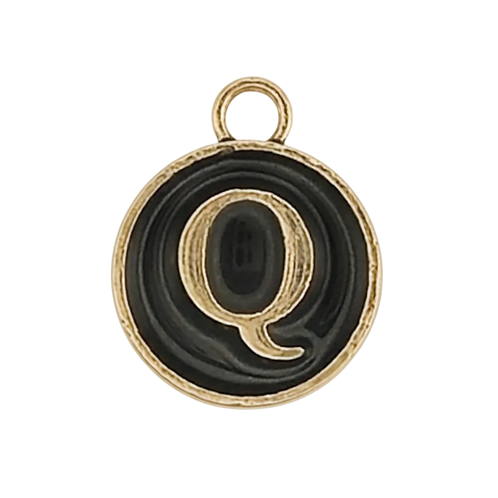 close-up of round black and gold charm with letter Q