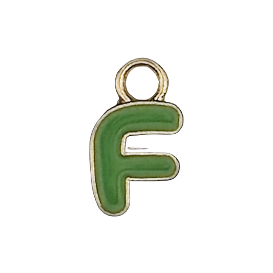 close-up of small green letter F charm with gold outline on black background