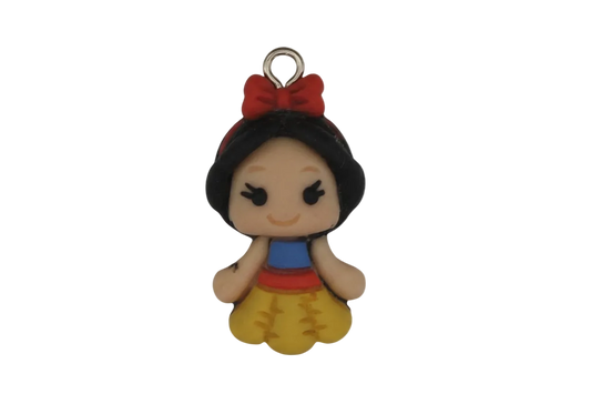 close-up of small cartoon princess charm with red bow and yellow skirt on a black background