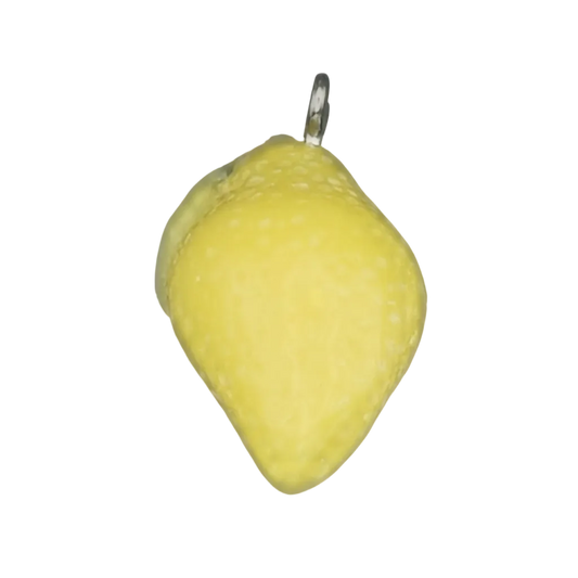 Close-up of a small yellow lemon-shaped charm on a black background.