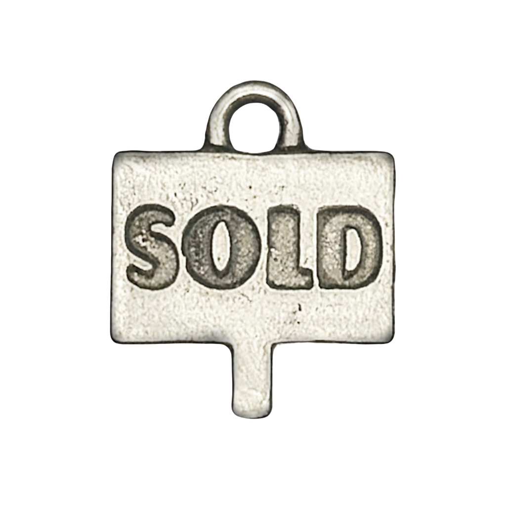 close-up of small silver charm shaped like a sign with the word SOLD