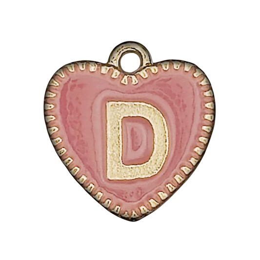 Close-up of a pink heart-shaped charm with a gold-tone letter D and edging on a black background.