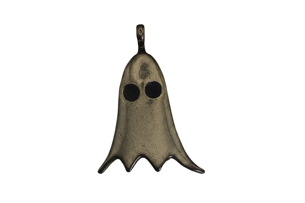 close-up bronze ghost charm with two round eyes on a black background