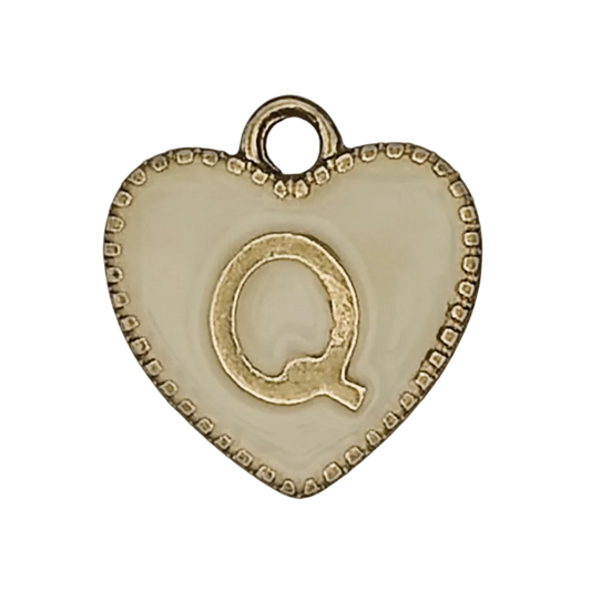 close-up of gold and cream heart charm with letter Q
