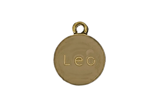 gold round charm with the word 'Leo' engraved