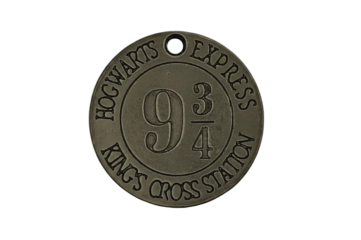 Close-up of round bronze charm engraved with 9 3/4, HOGWARTS EXPRESS, and KING'S CROSS STATION.