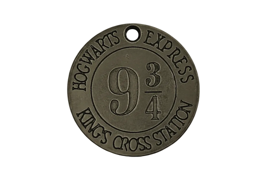 Close-up of round bronze charm engraved with 9 3/4, HOGWARTS EXPRESS, and KING'S CROSS STATION.