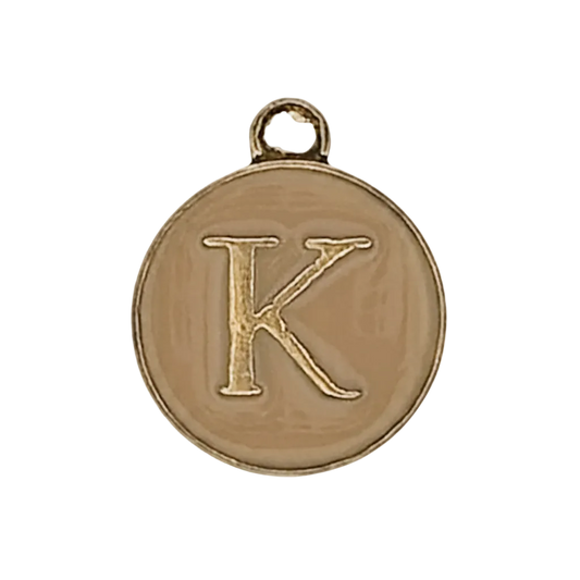 close-up of round gold-tone charm with engraved letter K