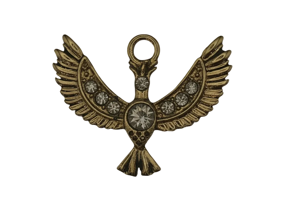 close-up of a gold winged bird charm with clear stones on a black background