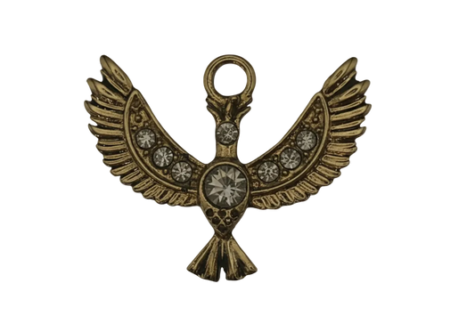 close-up of a gold winged bird charm with clear stones on a black background