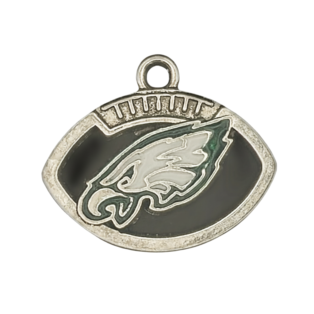 close-up of football-shaped metal charm with eagle head emblem in black and green enamel