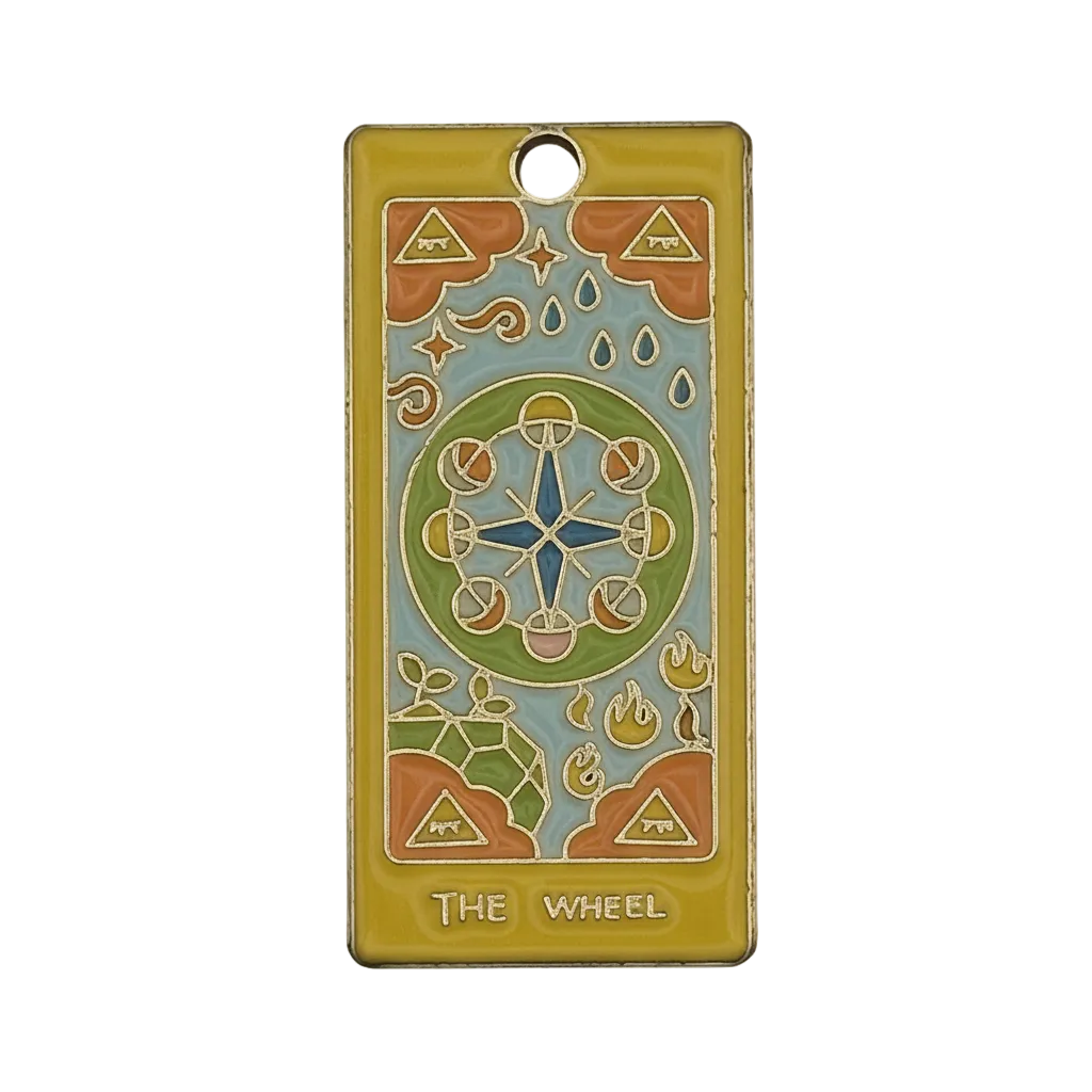 Close-up of rectangular enamel charm with 'THE WHEEL' tarot design in a gold-tone frame.